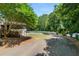 Home exterior with driveway, partial fencing, lush green trees and shrubs at 2166 Tanglewood Dr, Snellville, GA 30078
