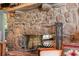 Detailed view of the stone fireplace with a hearth and decorative fireplace tools at 2166 Tanglewood Dr, Snellville, GA 30078