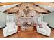 Inviting living room featuring a stone fireplace, exposed wood beams, and comfortable seating at 2166 Tanglewood Dr, Snellville, GA 30078