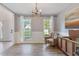 Sunlit dining room features wood floors, wainscoting, and modern light fixture at 2505 Hamilton Parc Ln, Buford, GA 30519