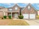 Beautiful brick home boasts a two-car garage, covered porch, and manicured landscaping at 3019 Iona Ct, Snellville, GA 30039