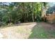Spacious backyard featuring green grass surrounded by mature trees and a wood fence at 3436 Adkins Nw Rd, Atlanta, GA 30331