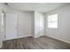 Bedroom features two entry doors, a window, neutral walls, and wood-look floors at 3436 Adkins Nw Rd, Atlanta, GA 30331
