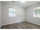 A bedroom featuring neutral walls, wood-look flooring, and natural light from two windows at 3436 Adkins Nw Rd, Atlanta, GA 30331