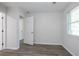 Neutral bedroom featuring hardwood floors, a window with blinds, and a doorway to another room at 3436 Adkins Nw Rd, Atlanta, GA 30331