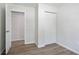 Bedroom with an open closet, bi-fold doors, neutral walls, and wood-look flooring at 3436 Adkins Nw Rd, Atlanta, GA 30331