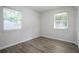 A bedroom featuring neutral walls, wood-look flooring, and natural light from two windows at 3436 Adkins Nw Rd, Atlanta, GA 30331
