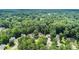 Aerial view of a neighborhood showcasing lush green landscaping and mature trees surrounding well-maintained homes at 114 Arborwood Way, Temple, GA 30179