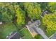 Aerial view of a home featuring mature trees, well-maintained lawn, a long driveway, and fenced yard at 114 Arborwood Way, Temple, GA 30179