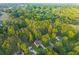 Aerial view showcasing lush tree canopy in a quiet neighborhood with manicured lawns surrounding well-maintained homes at 114 Arborwood Way, Temple, GA 30179