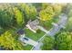 An aerial view of a charming home with a lush green lawn, mature trees, detached garage, and private driveway at 114 Arborwood Way, Temple, GA 30179