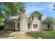 The backyard of a tan two-story home featuring a small patio and lush green trees at 114 Arborwood Way, Temple, GA 30179