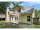 The backyard of a tan two-story home featuring a small patio, fenced yard and lush trees at 114 Arborwood Way, Temple, GA 30179