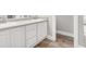 Bathroom vanity area featuring double sinks, white cabinets, gray countertops, and wood-look floors at 114 Arborwood Way, Temple, GA 30179