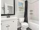 Bright bathroom featuring a white vanity, black fixtures, and a shower with a gray shower curtain and corner shelves at 114 Arborwood Way, Temple, GA 30179