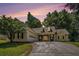 Single-story home with a two-car garage, manicured lawn, and inviting stone-accented entryway at dusk at 114 Arborwood Way, Temple, GA 30179