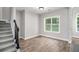 Versatile flex room featuring hardwood flooring, a window with backyard view, and access to the stairs at 114 Arborwood Way, Temple, GA 30179