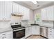 Updated kitchen with white cabinetry, stainless appliances, granite countertops and a decorative tile backsplash at 114 Arborwood Way, Temple, GA 30179