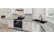 Modern kitchen featuring granite countertops, white cabinets, stainless steel appliances, and stylish backsplash at 114 Arborwood Way, Temple, GA 30179