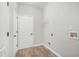 Utility room featuring hookups for a washer and dryer, multiple doors, and wood-look floors at 114 Arborwood Way, Temple, GA 30179