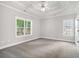 Spacious main bedroom featuring neutral paint, carpeted floors, a tray ceiling, and natural light at 114 Arborwood Way, Temple, GA 30179