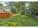 Picturesque backyard with lush lawn, mature trees, and fenced area at 1651 King Rd, Riverdale, GA 30296