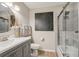 Updated bathroom showcases modern vanity, a large mirror, and a shower/tub combo with sliding glass door at 1651 King Rd, Riverdale, GA 30296