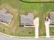A bird's eye view of a grey roof house surrounded by a green yard on a sunny day at 149 Elkins Blvd, Locust Grove, GA 30248