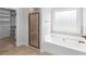 This primary bathroom features a soaking tub and a glass-enclosed shower at 149 Elkins Blvd, Locust Grove, GA 30248