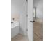 View of the soaking tub area with a tiled surround and a doorway to the bedroom at 149 Elkins Blvd, Locust Grove, GA 30248