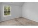 An ample bedroom featuring neutral-colored walls and carpet, with a window view at 149 Elkins Blvd, Locust Grove, GA 30248