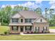 Inviting two-story home with brick and siding, mature landscaping, and a well-manicured lawn at 149 Elkins Blvd, Locust Grove, GA 30248