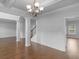 Spacious living area with hardwood floors, elegant columns, wainscoting and stairs to upper level at 149 Elkins Blvd, Locust Grove, GA 30248