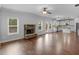 Bright living room with hardwood floors and stone fireplace adjacent to kitchen and dining area at 149 Elkins Blvd, Locust Grove, GA 30248