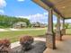 Inviting covered porch with brick-based columns and views of the landscaped front yard and neighboring homes at 149 Elkins Blvd, Locust Grove, GA 30248