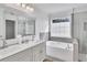 Bright bathroom featuring double vanity, soaking tub, and glass enclosed shower at 11739 Sawgrass Ct, Fayetteville, GA 30215