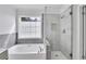 Bright bathroom showcasing the shower with grey tile and glass door and soaking tub at 11739 Sawgrass Ct, Fayetteville, GA 30215