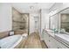 A luxurious bathroom featuring double sinks, a bathtub, and a glass-enclosed shower at 1618 Durden Ne Rd, Atlanta, GA 30319