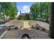 Large backyard with a stone fire pit and a terraced landscape leading up to a covered deck at 4020 High Gables E, Cumming, GA 30041