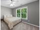 Neutral tone bedroom with a light ceiling fan, window view and striped bedding at 4020 High Gables E, Cumming, GA 30041