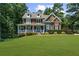Charming two-story home with a manicured lawn, lush landscaping, and inviting front porch at 4020 High Gables E, Cumming, GA 30041