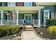 Inviting front porch featuring a swing, patriotic decor, and beautiful flowers at 4020 High Gables E, Cumming, GA 30041