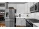 This charming kitchen features stainless appliances, white cabinets, and quartz countertops at 4020 High Gables E, Cumming, GA 30041