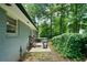 Cozy backyard patio includes outdoor furniture, green space, and a privacy hedge at 506 Bolijeri Blvd, Villa Rica, GA 30180