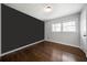 Empty bedroom with neutral walls, hardwood floors, and natural light from double windows at 506 Bolijeri Blvd, Villa Rica, GA 30180
