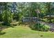 Charming single-story home with a well-manicured lawn, mature trees and American flag in a wooded setting at 506 Bolijeri Blvd, Villa Rica, GA 30180