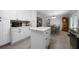 Open kitchen showcasing white cabinetry, an island, stainless steel appliances, and an adjacent dining room at 506 Bolijeri Blvd, Villa Rica, GA 30180