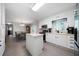 Kitchen with white cabinetry, black appliances, and a kitchen island with an open dining area at 506 Bolijeri Blvd, Villa Rica, GA 30180