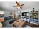 Open living room with hardwood floors, an L-shaped sofa, a view to the kitchen, and custom built-in bookcases at 506 Bolijeri Blvd, Villa Rica, GA 30180
