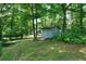 Outdoor shed in a backyard setting, surrounded by mature trees and lush greenery at 506 Bolijeri Blvd, Villa Rica, GA 30180